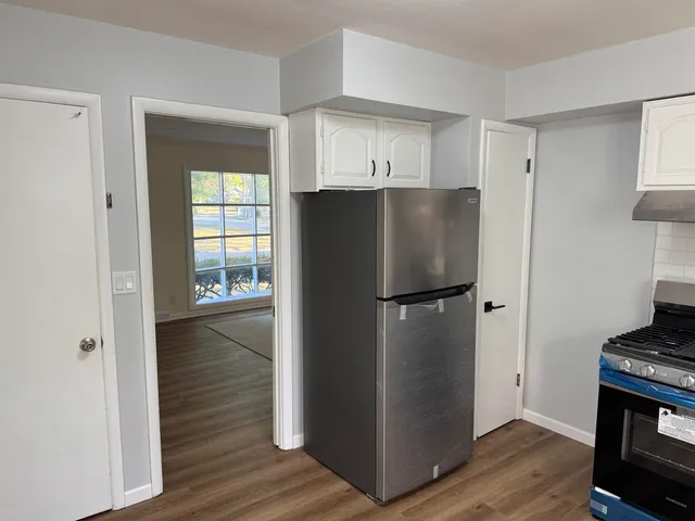 a kitchen with a refrigerator and a stove top oven