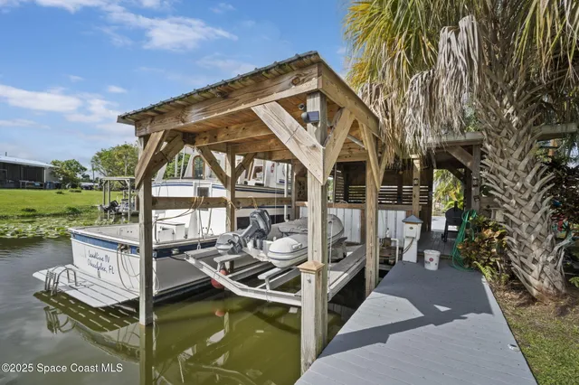 a view of a roof deck with table and chairs with wooden floor and fence