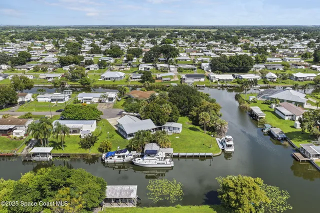 an aerial view of residential houses with outdoor space and river