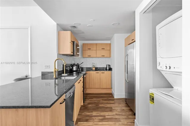 a kitchen with stainless steel appliances granite countertop a sink stove and refrigerator