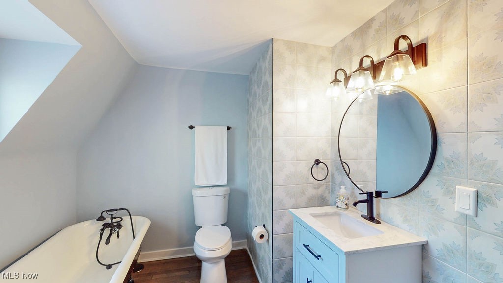 3077 Huntington Road Cleveland, OH 44120 - Photo 28 of 37 Full bath with a freestanding tub, vanity, tile walls, and dark wood-style flooring
