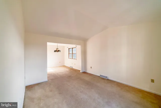 an empty room with windows and chandelier