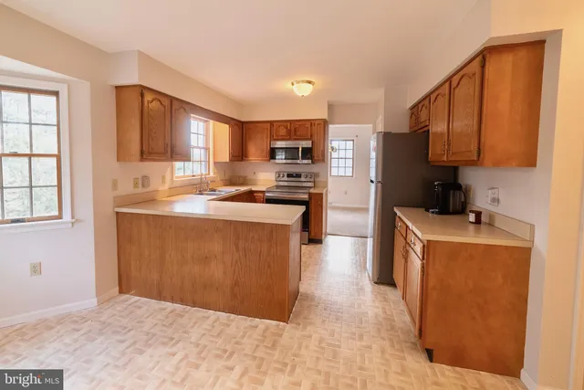 a kitchen with stainless steel appliances granite countertop a stove a sink a refrigerator and a microwave