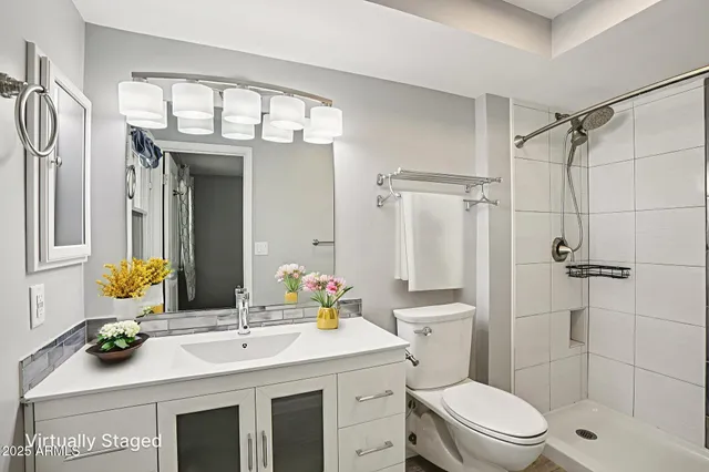 a bathroom with a sink a toilet and shower