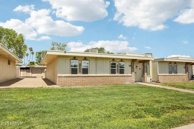 a view of a house with a yard and sitting area