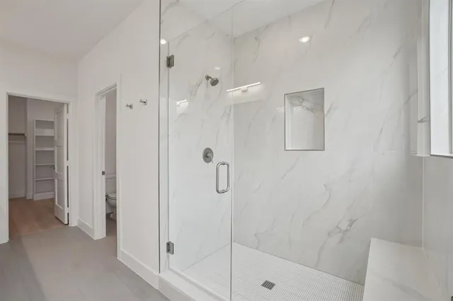 an empty room with wooden floor chandelier fan and windows
