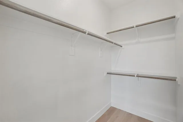 an empty room with a window and ceiling fan