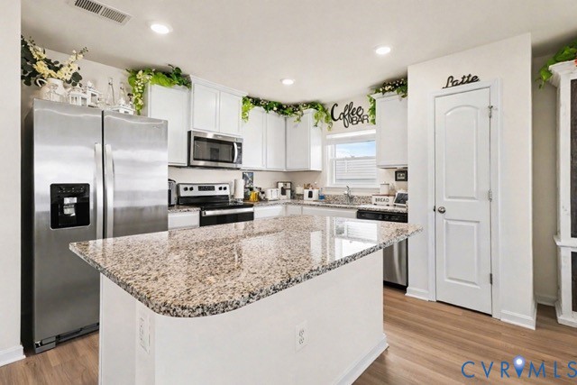 a kitchen with stainless steel appliances granite countertop a refrigerator a stove and a sink