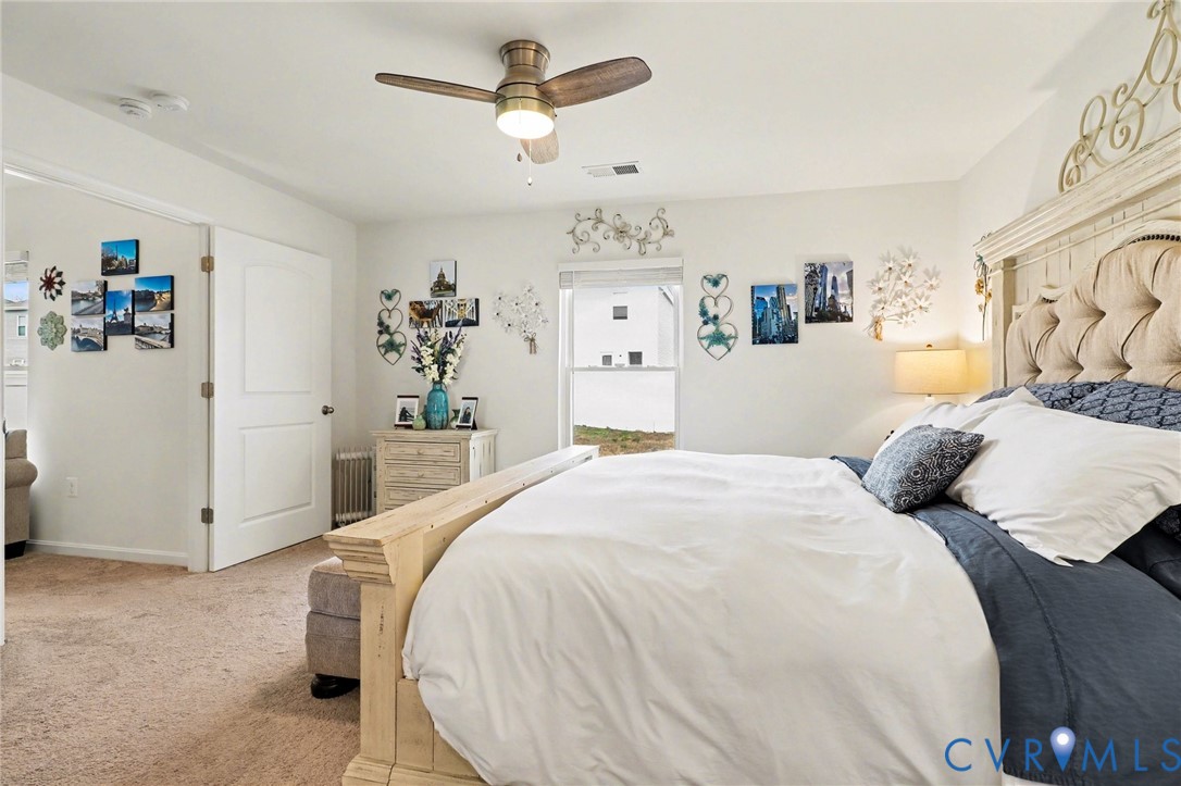 17075 Rollins Road Bowling Green, VA 22427 - Photo 13 of 23 a bedroom with a large bed and a chandelier