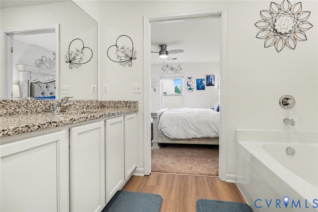 17075 Rollins Road Bowling Green, VA 22427 - Photo 14 of 23 a en suite bathroom with a granite countertop sink and a mirror