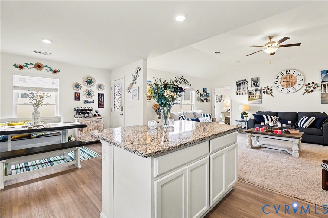17075 Rollins Road Bowling Green, VA 22427 - Photo 6 of 23 a kitchen with stainless steel appliances granite countertop a sink dishwasher and a dining table with wooden floor
