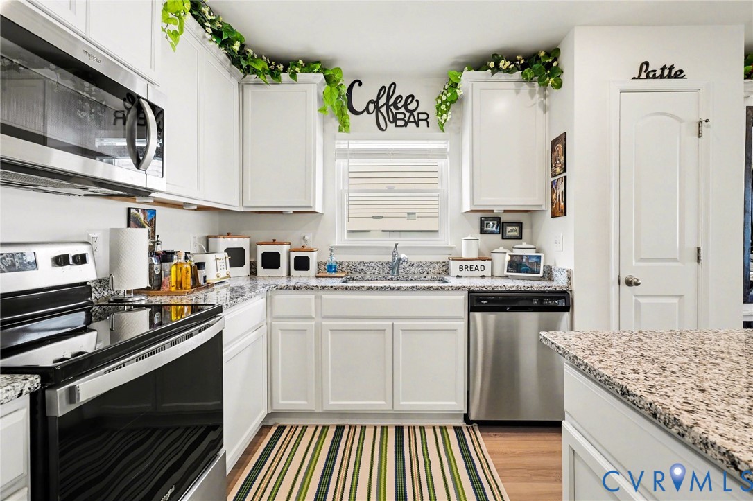 17075 Rollins Road Bowling Green, VA 22427 - Photo 6 of 16 a kitchen with granite countertop white cabinets and white appliances