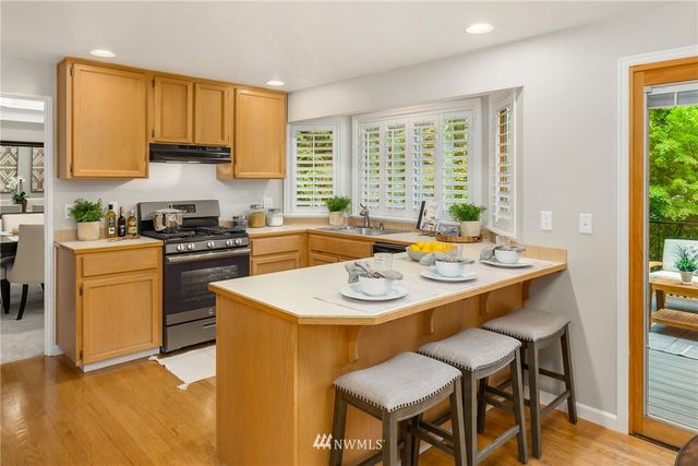a kitchen with a stove a sink a kitchen island with a dining table and chairs
