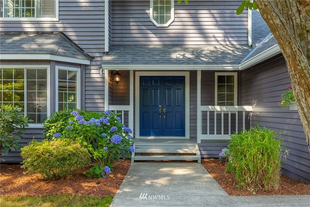 a view of brick house with potted plants and a table