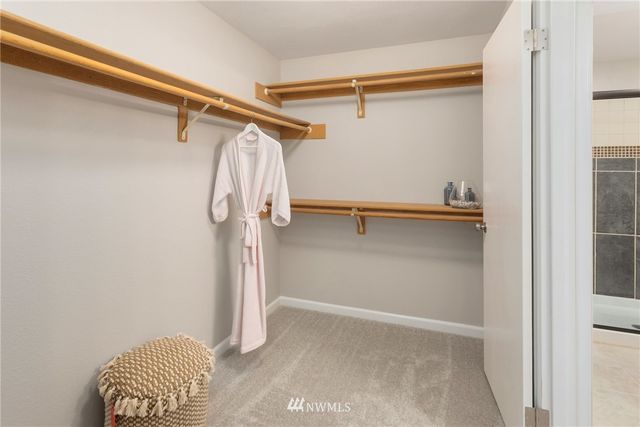 a view of walk in closet with clothes and shoes