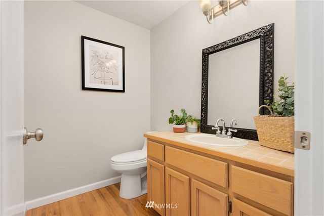 a bathroom with a granite countertop sink mirror vanity and toilet