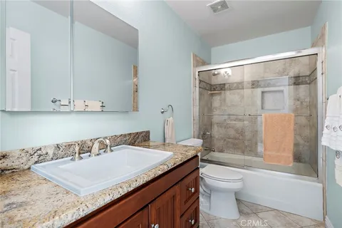 a bathroom with a granite countertop sink toilet and shower