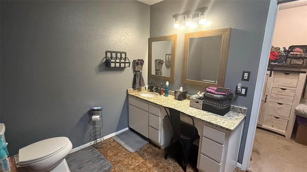 1356 Kerry Lane Azle, TX 76020 - Photo 13 of 27 Bathroom featuring a dual vanity with a light-toned granite-style countertop, two framed mirrors, and a multi-bulb light fixture