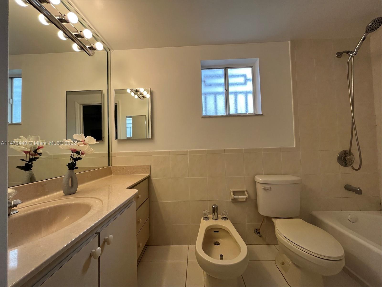 2988 Southwest 11th Street, Unit 2988 Miami, FL 33135 - Photo 11 of 22 a bathroom with a toilet sink and mirror