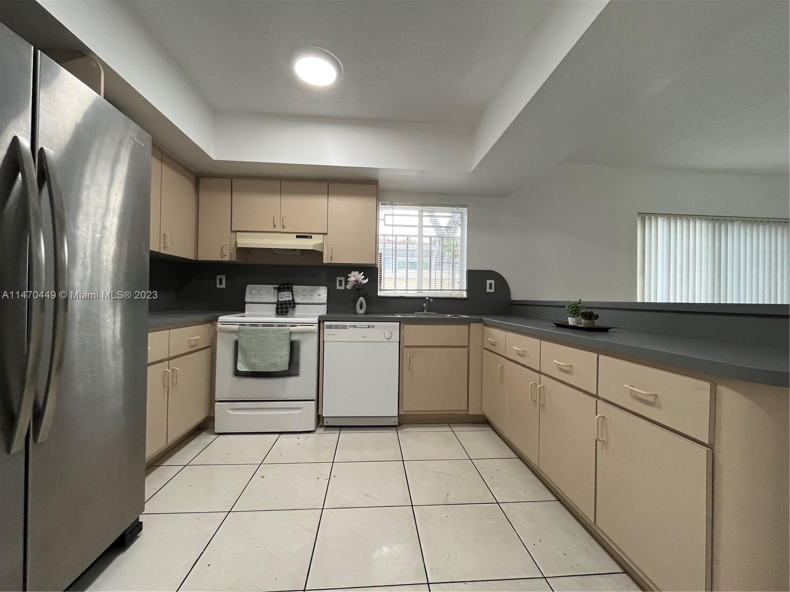 2988 Southwest 11th Street, Unit 2988 Miami, FL 33135 - Photo 3 of 22 a kitchen with a sink a stove top oven and cabinets