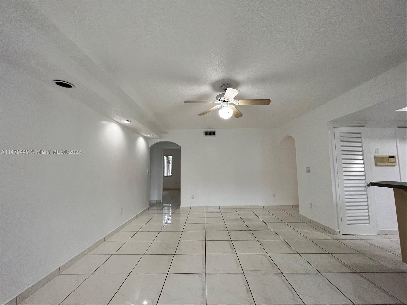 2988 Southwest 11th Street, Unit 2988 Miami, FL 33135 - Photo 8 of 22 a view of an empty room with window and chandelier fan