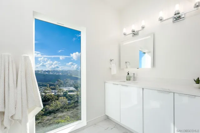 a bathroom with a granite countertop sink a mirror and shower