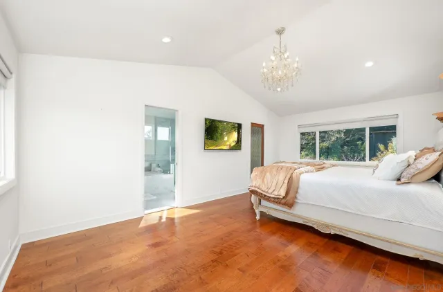 a bed sitting in a spacious bedroom next to a window
