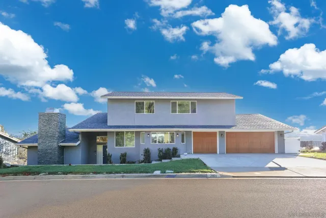 a view of a big house with a big yard and large tree