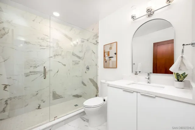 a bathroom with a sink a toilet and shower