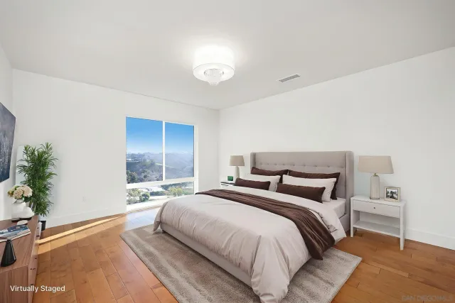 a bedroom with a large bed and potted plant