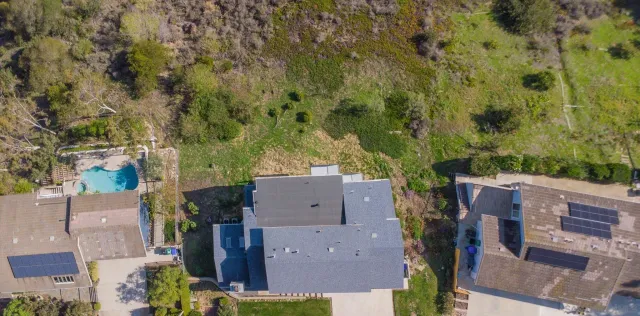 an aerial view of house with yard and outdoor seating