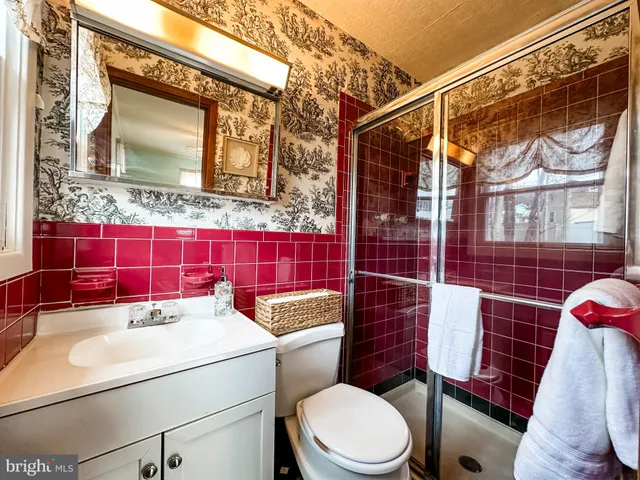 a bathroom with a sink toilet vanity and shower