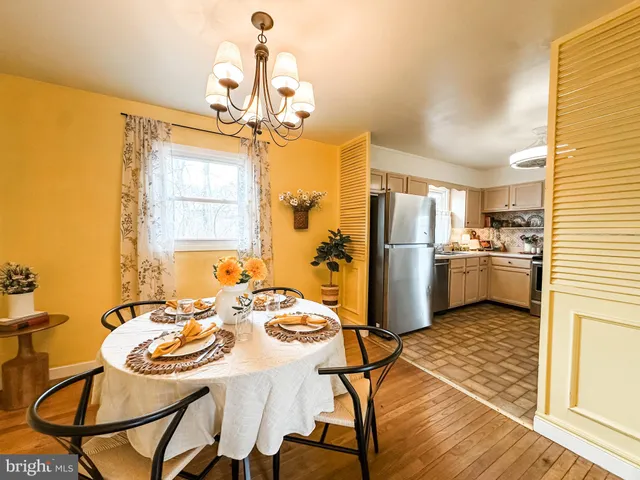 a kitchen with stainless steel appliances kitchen island granite countertop a dining table chairs and granite counter tops