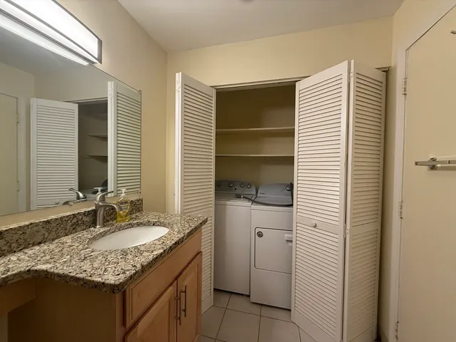 a bathroom with a granite countertop sink and a mirror