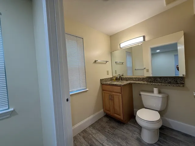 a bathroom with a toilet a sink and mirror