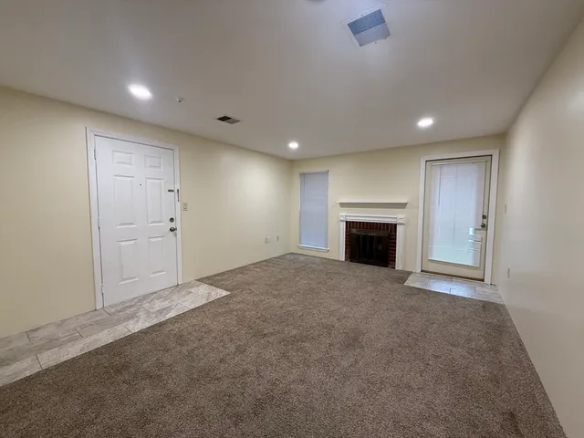 a view of empty room with a fireplace