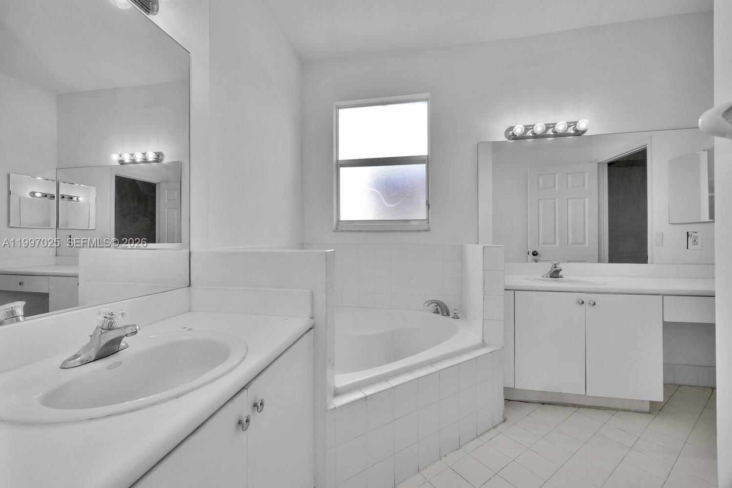 12864 Southwest 133rd Terrace Miami, FL 33186 - Photo 13 of 26 a bathroom with a bathtub sink and mirror