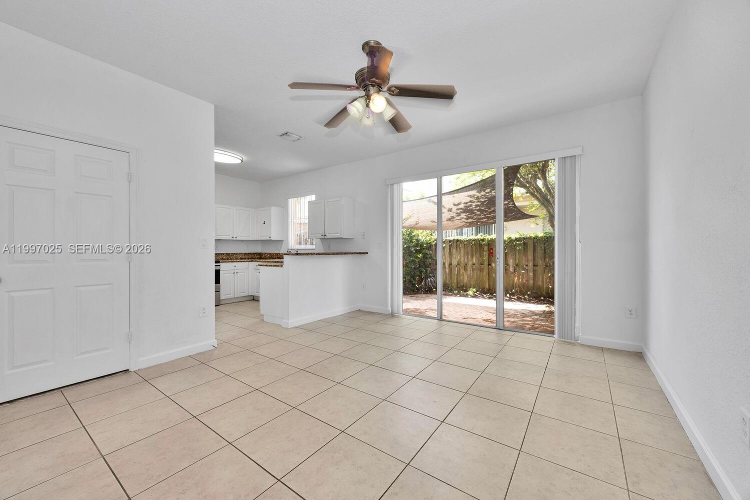 12864 Southwest 133rd Terrace Miami, FL 33186 - Photo 3 of 26 a view of a kitchen with furniture ceiling fan and window