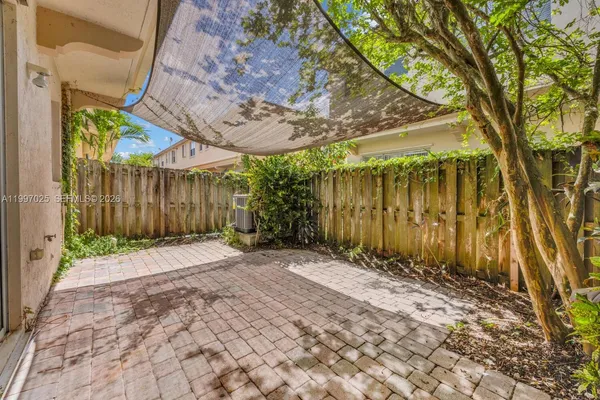 a backyard of a house with a tree and wooden fence
