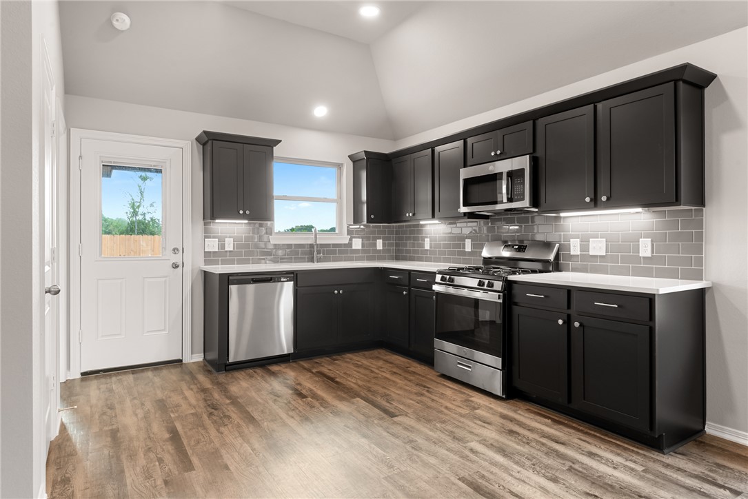 2869 Messenger Way Bryan, TX 77803 - Photo 9 of 23 a kitchen with stainless steel appliances granite countertop a stove sink microwave and cabinets