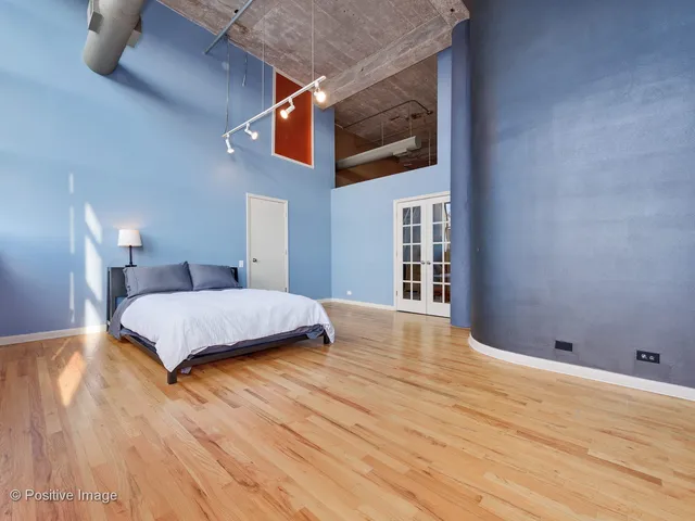 a bedroom with a bed and wooden floor