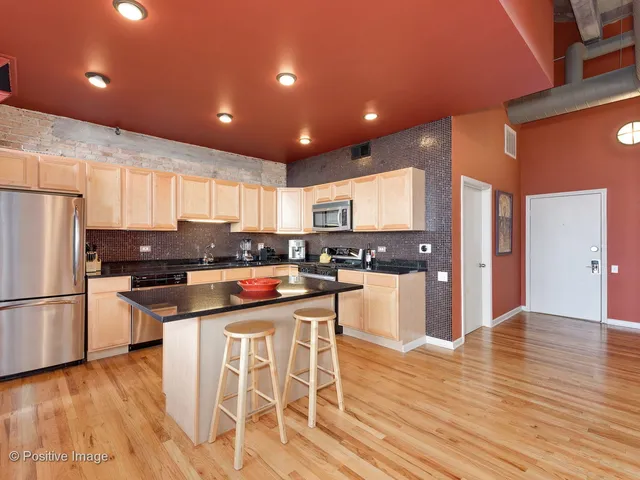 a kitchen with stainless steel appliances granite countertop a refrigerator and a stove top oven