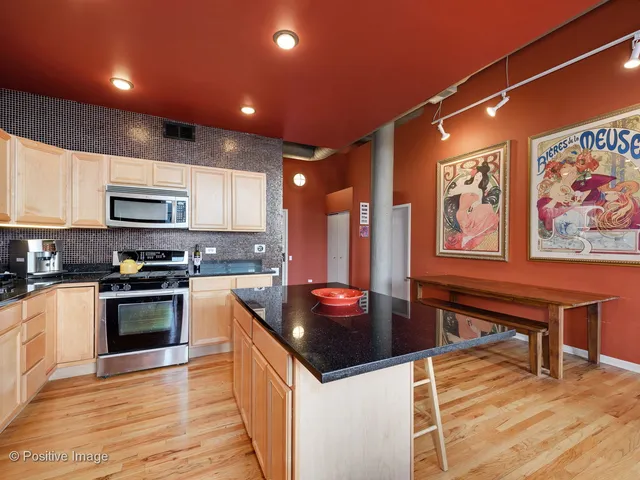 a kitchen with stainless steel appliances granite countertop a stove a sink and a microwave