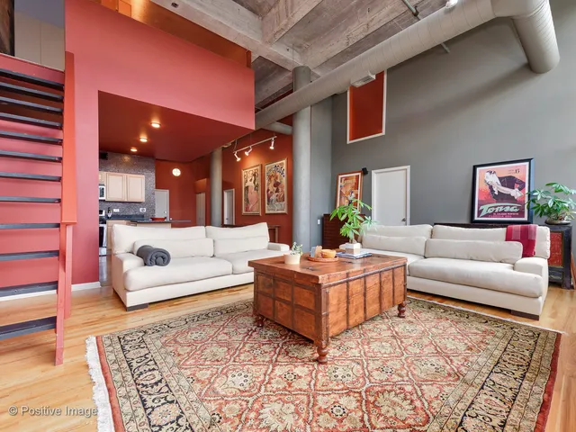 a living room with fireplace furniture and a rug