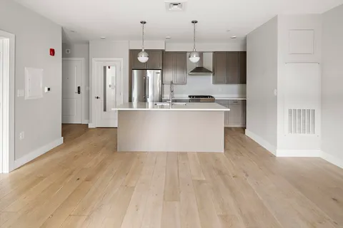 a view of kitchen with stainless steel appliances granite countertop a stove and a sink