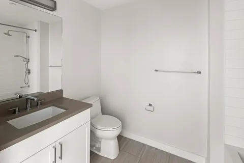 a bathroom with a granite countertop toilet and sink