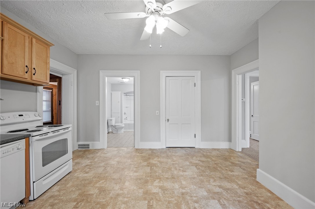 19258 Lunn Road Strongsville, OH 44149 - Photo 11 of 34 Kitchen with white appliances, a textured ceiling, ceiling fan, and light tile floors