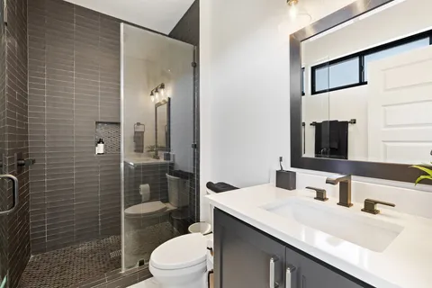 a bathroom with a sink a toilet and shower