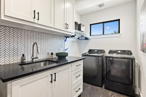 a kitchen with granite countertop white cabinets and stainless steel appliances