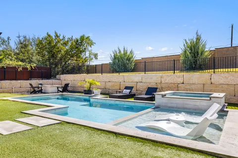 a view of a swimming pool with a patio and a yard